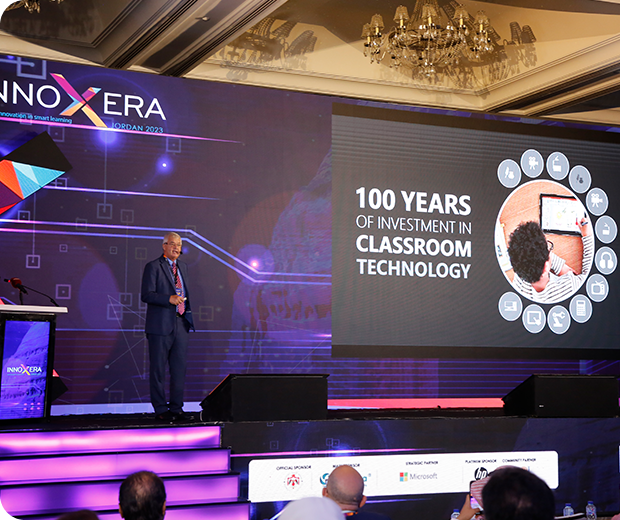 A group picture with a man sitting in the middle above a table that has the Classera logo on it